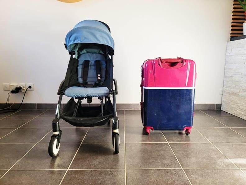 YOYO Babyzen stroller unfolded next to a cabin suitcase